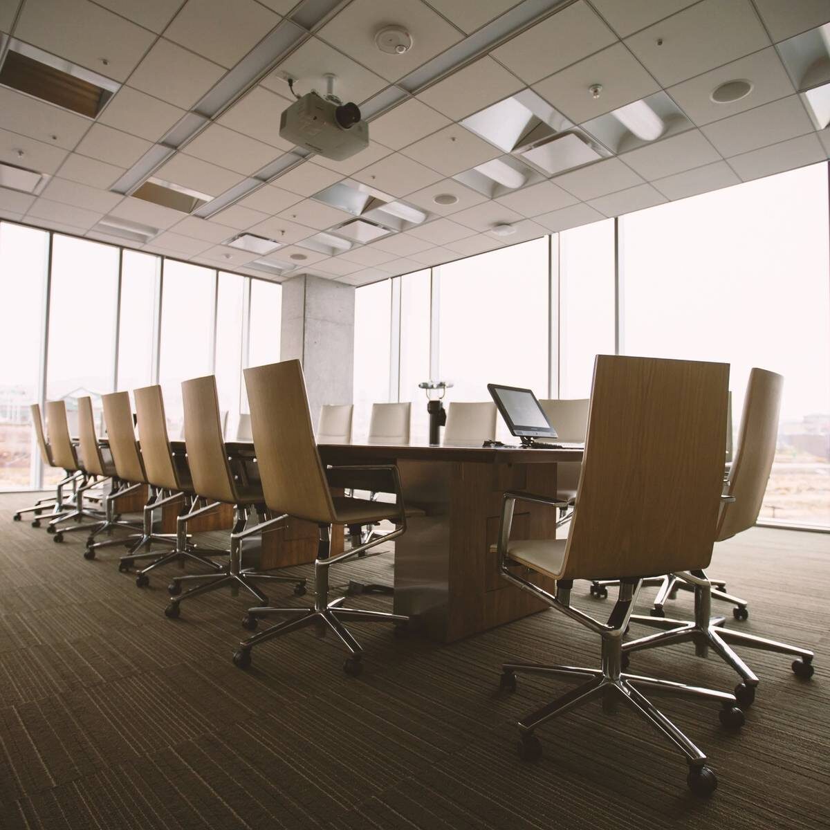 Una sala de juntas en un edificio corporativo con ventanales lista para una consultoría para negocios